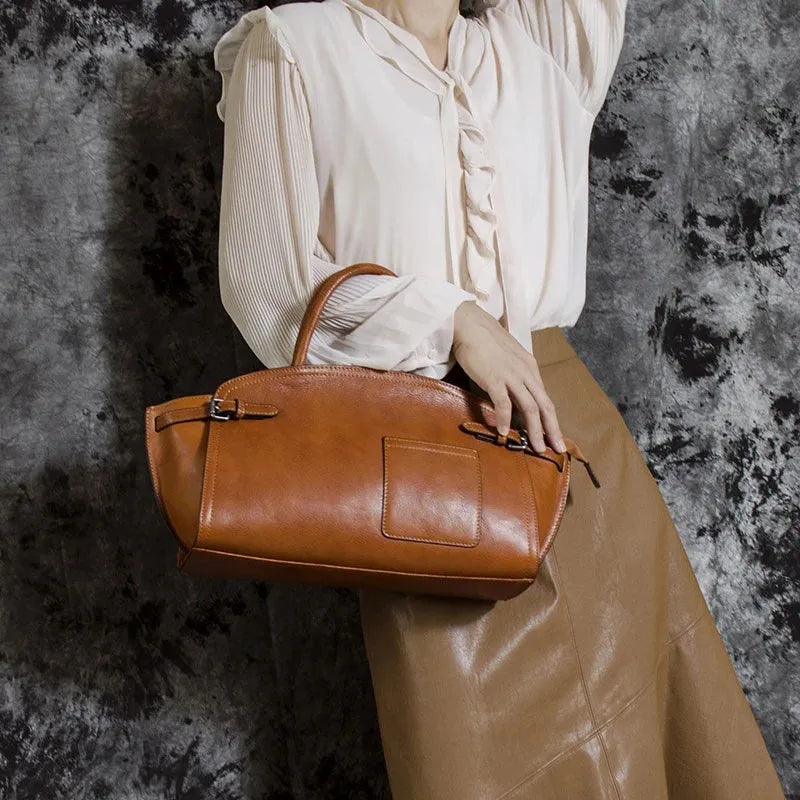 Genuine top grain leather women's crossbody bag in brown with dumpling shape and zip closure.