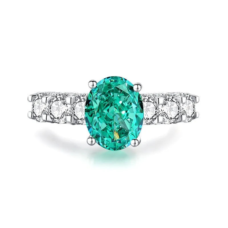 S925 silver ring with an inlaid green emerald stone and sparkling diamond detailing on a geometric band.