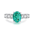 S925 silver ring with an inlaid green emerald stone and sparkling diamond detailing on a geometric band.