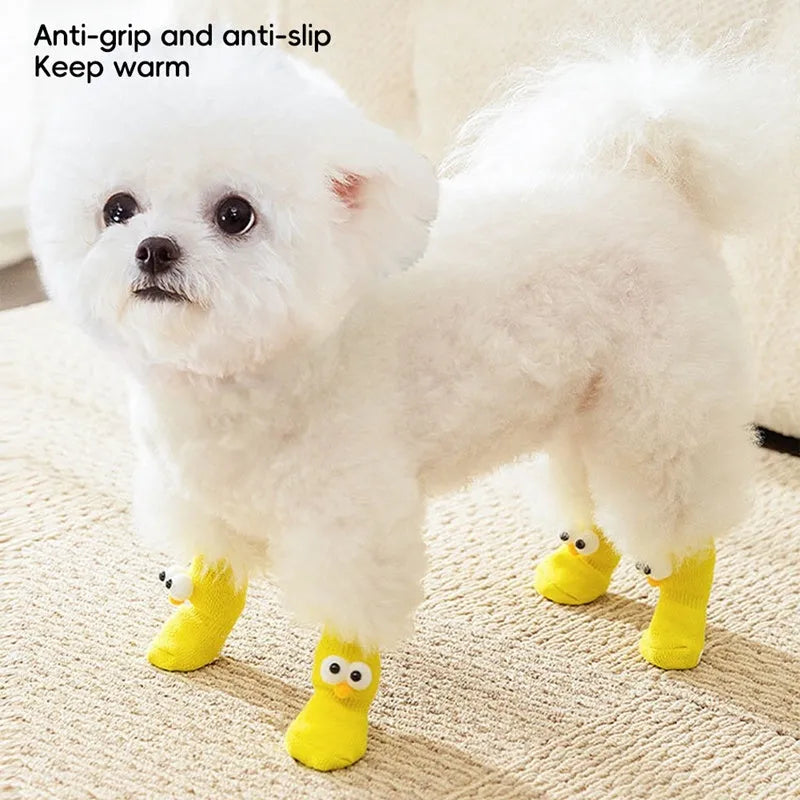 Dog wearing green non-slip socks with cartoon big eyes pattern on wooden floor
