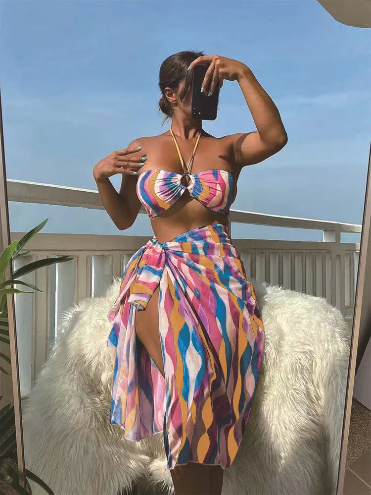 Women's yellow green three-piece bikini set with matching printed beach skirt laid flat.