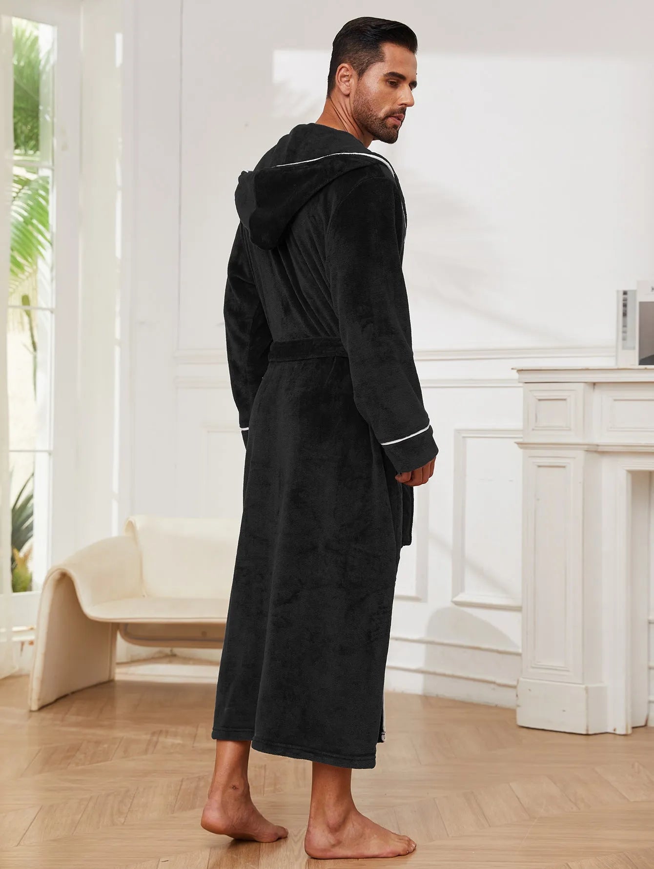 Man wearing a light grey flannel-style bathrobe at home, showing the front wrap design and soft texture.