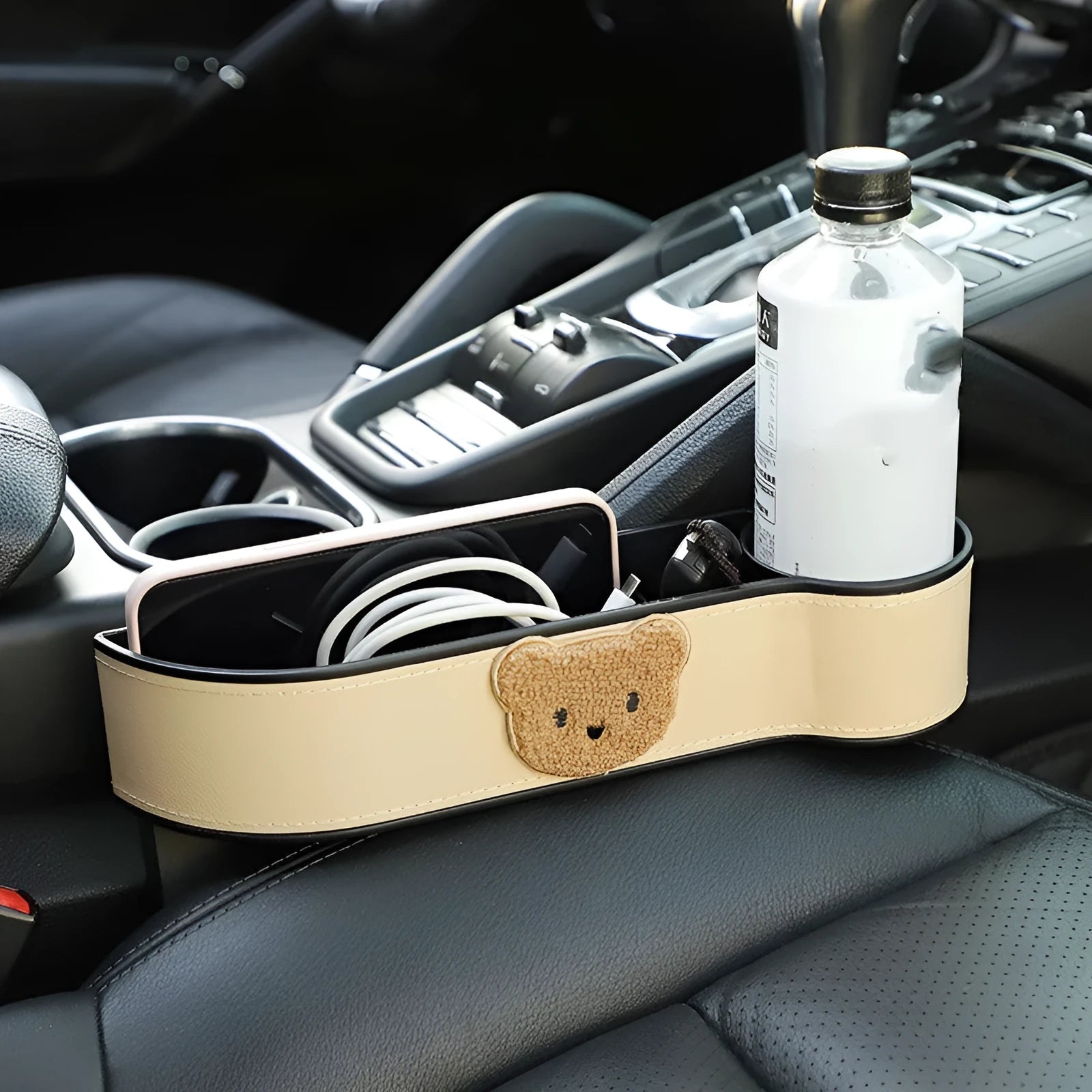 Leather car seat gap storage box with a cartoon bear design, shown hanging between vehicle seats.
