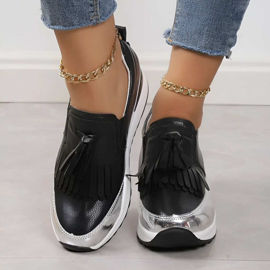 Women's black and white platform casual shoes with tassel detail and a muffin wedge heel