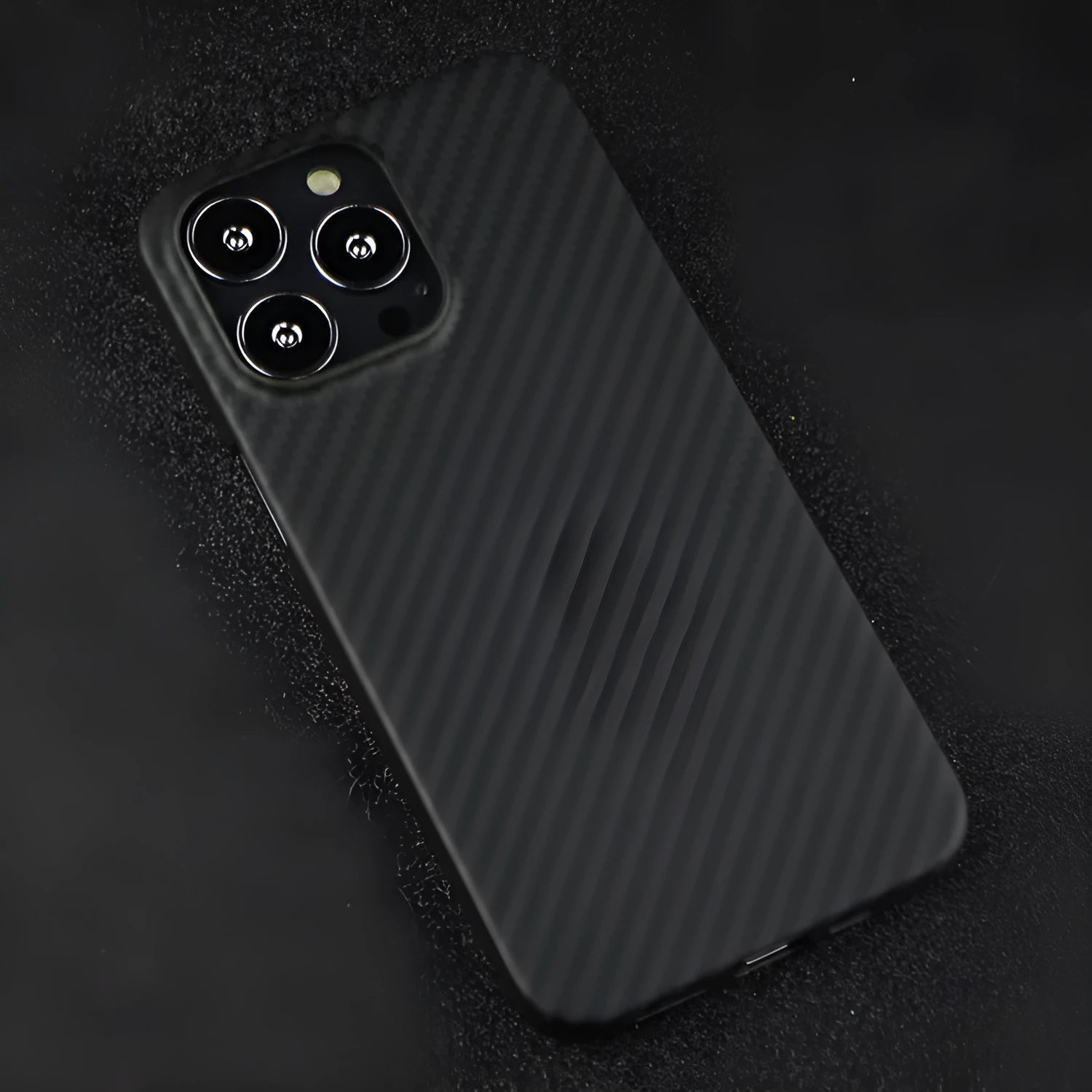 Dull black Kevlar fibre iPhone case with textured volcanic crater pattern and MagSafe magnetic rings