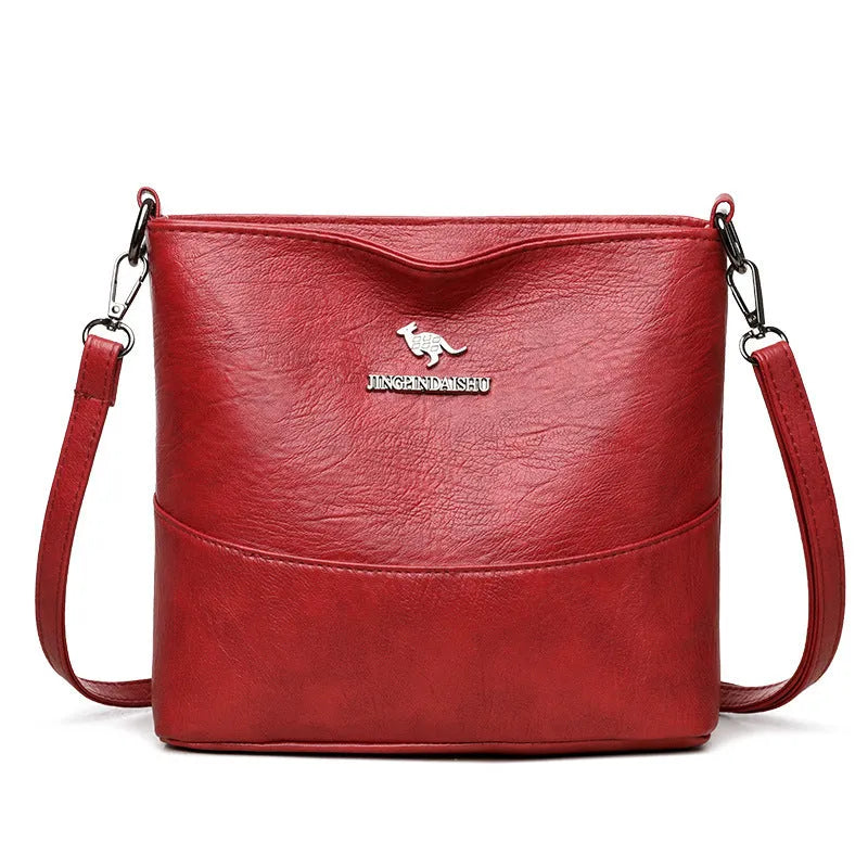 Women's PU leather crossbody bucket bag with wide strap, outer slit pocket, and internal phone and file pockets.