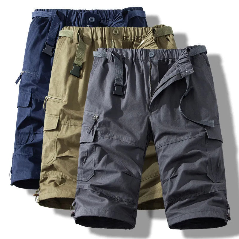 Man wearing thin cotton cropped overalls in army green, showing the relaxed summer fit.
