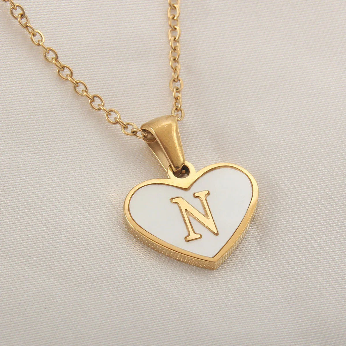 A personalized heart-shaped necklace with a 26-letter charm, crafted from high-quality stainless steel and gold plating.