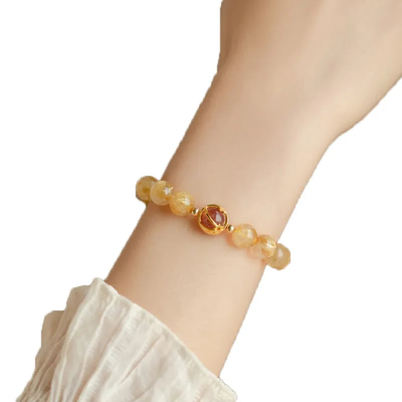 Gold rutilated quartz crystal bracelet with diamond-cut beads in a Korean-style design.