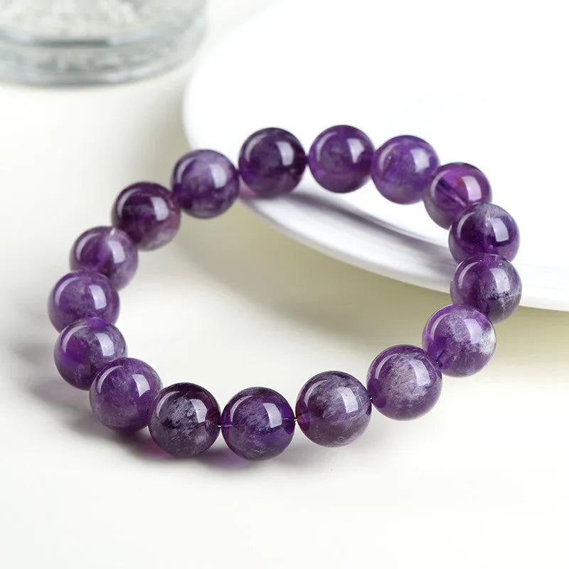 Natural Feather Amethyst purple crystal bracelet with scattered geometric beads on a wrist.