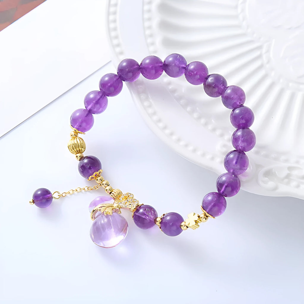 Purple crystal bracelet with geometric shapes, money bag pendant and peace buckle on wrist