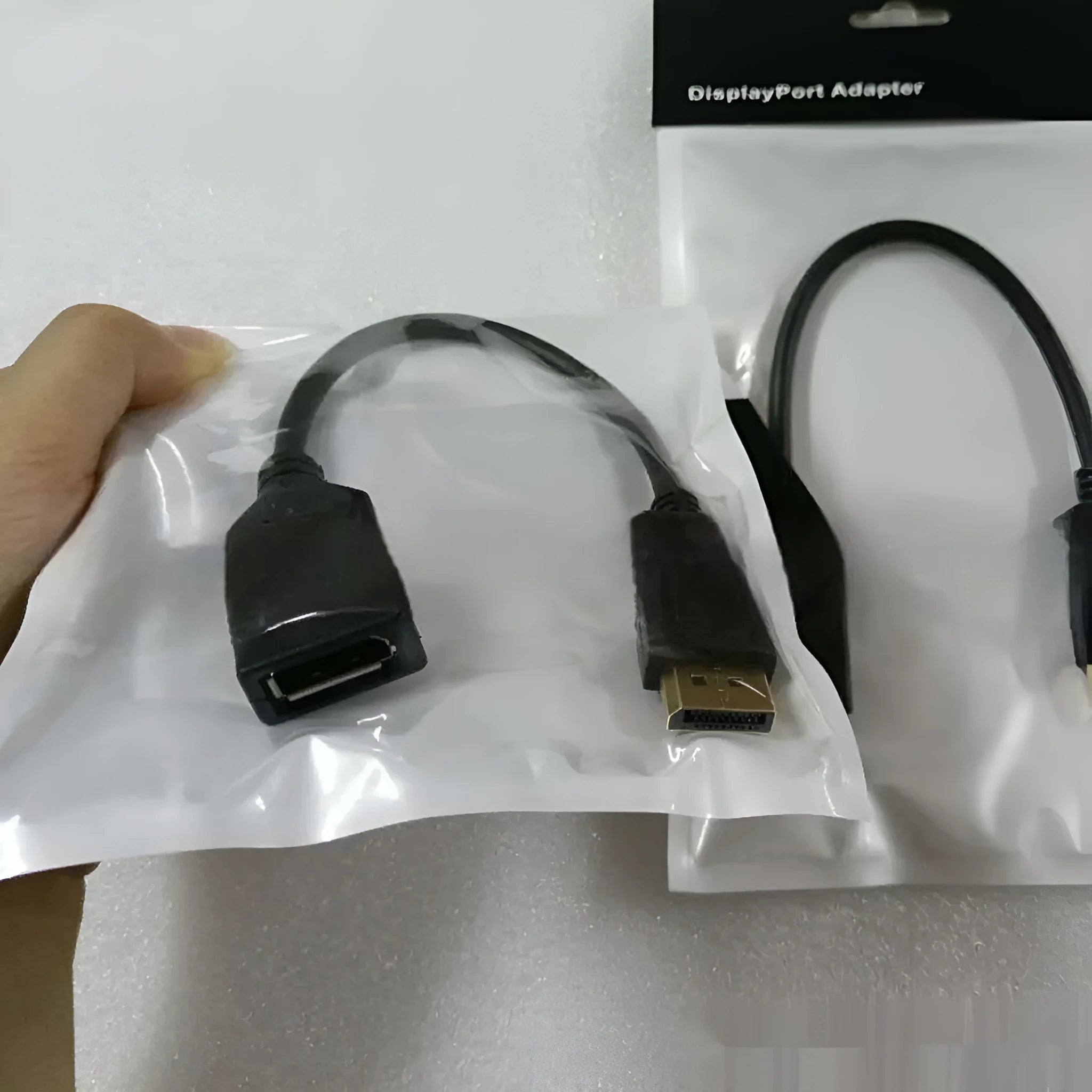 Black Display Port DP male to female extension cable with rotating connector, approximately 10cm long