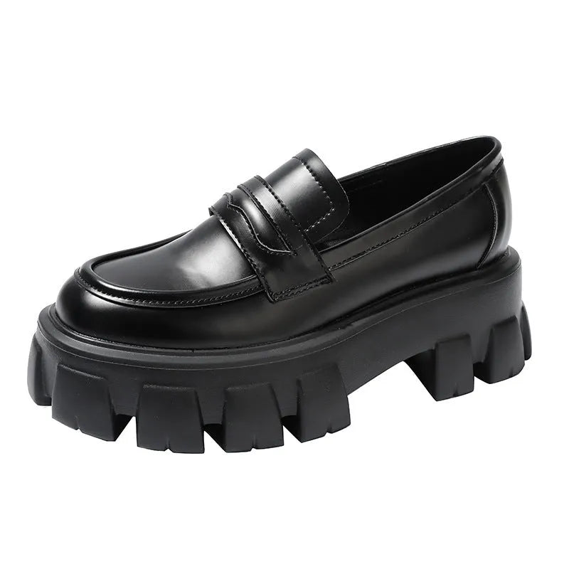 A pair of British style wide fit loafers in patent leather with a rubber sole.