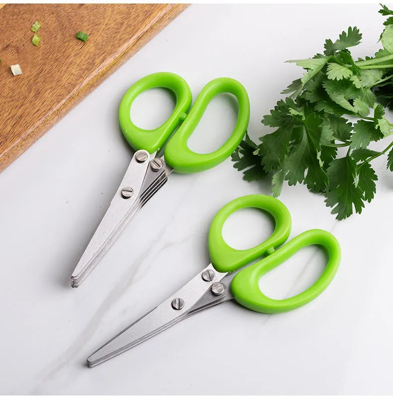 Stainless steel multi-blade kitchen scissors for cutting onions and herbs on a chopping board.