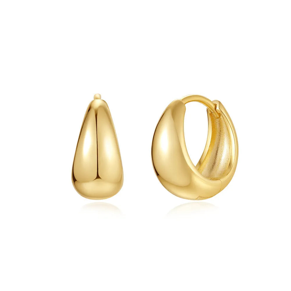 A pair of round geometric brass clip earrings with a gold electroplated finish on a white background.