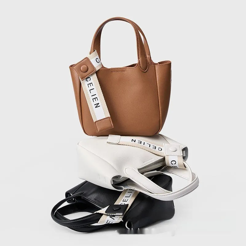 Brown cattlehide leather cross body bucket bag with square vertical shape and visible stitching