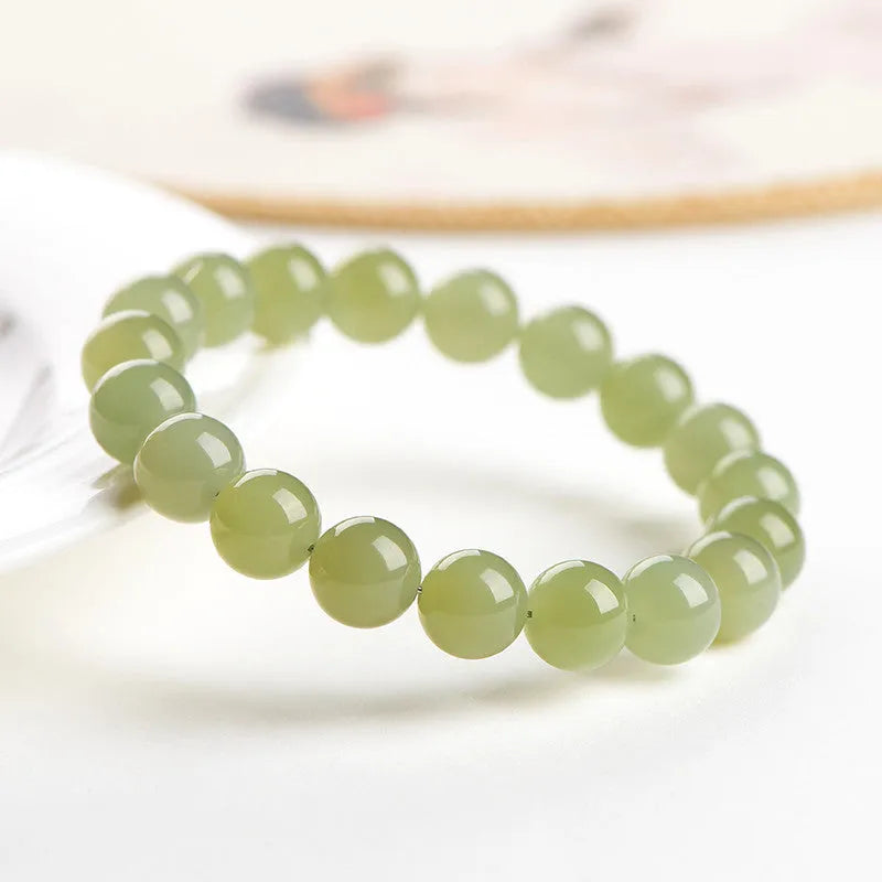 Hand-polished Hetian jade ball bracelet on wrist, showing deep water clear beads.