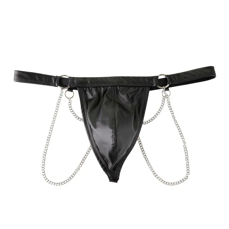 Black men's patent leather thong underwear with metal chain decoration on a grey background.