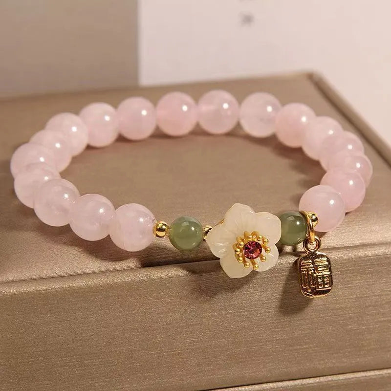 Crystal and Hetian Jade beaded bracelet with peach blossom design and adjustable cord.