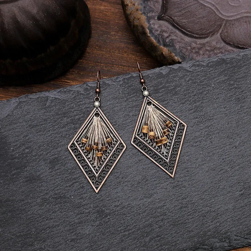 Bohemian hand-woven gold thread alloy earrings with geometric quadrilateral shape on a white background