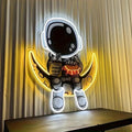 Blue and yellow astronaut and moon LED neon light mounted on a wall.