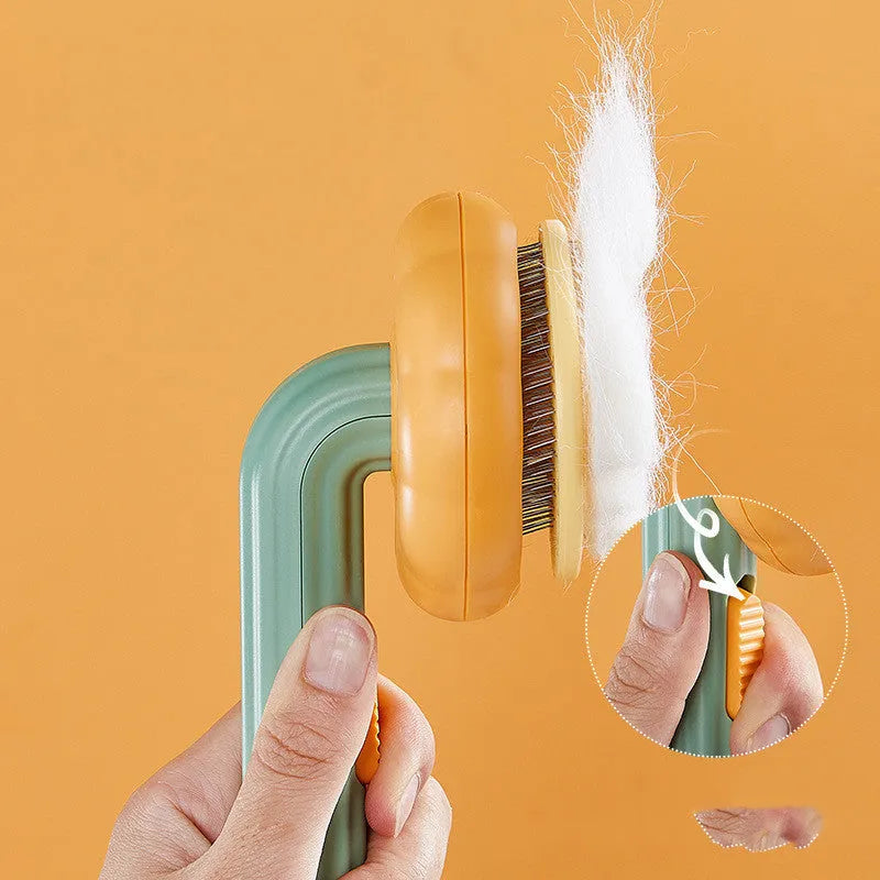 Hand-held pet grooming brush with stainless steel needles in pumpkin colour design