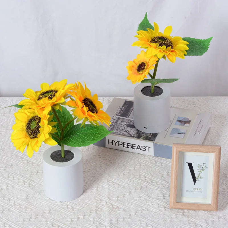 Rechargeable artificial sunflower LED night light on a table with USB charging cable.
