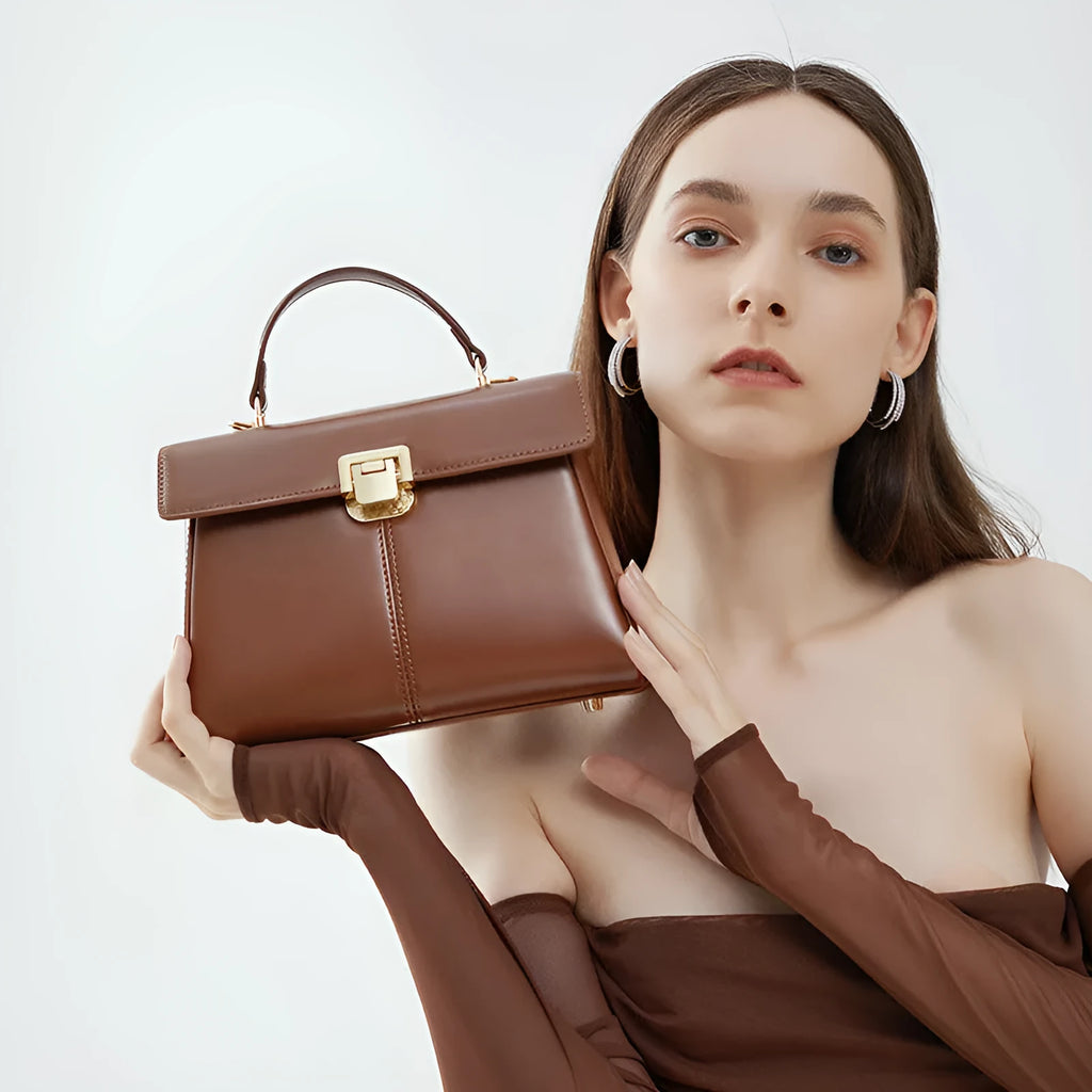 Women's black genuine leather shoulder bag with vachette clasp closure showing internal compartments