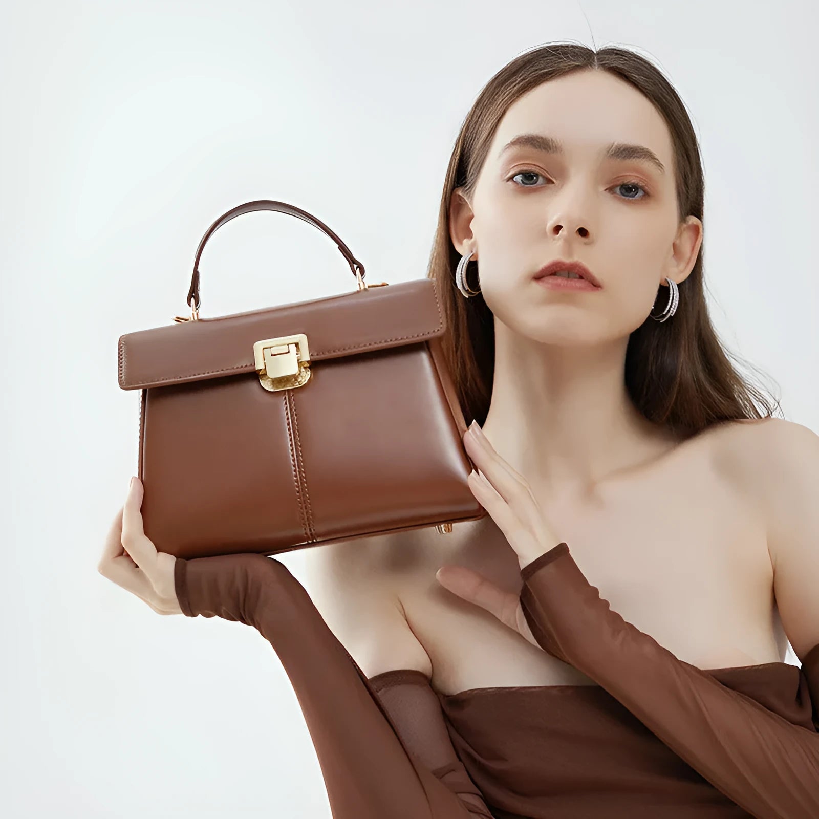 Women's black genuine leather shoulder bag with vachette clasp closure showing internal compartments