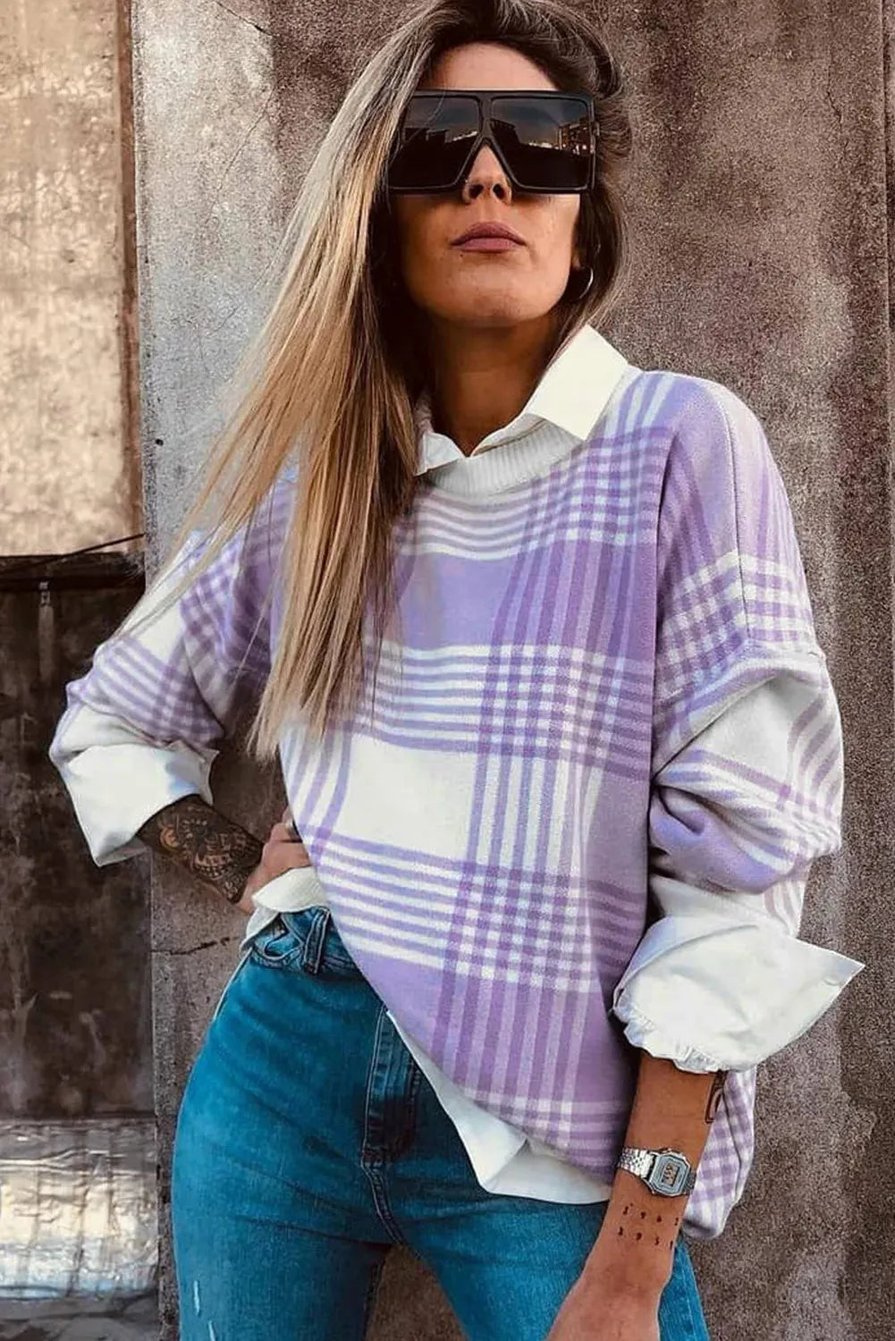 Lilac plaid print loose sweater with ribbed cuffs and hem on a hanger.