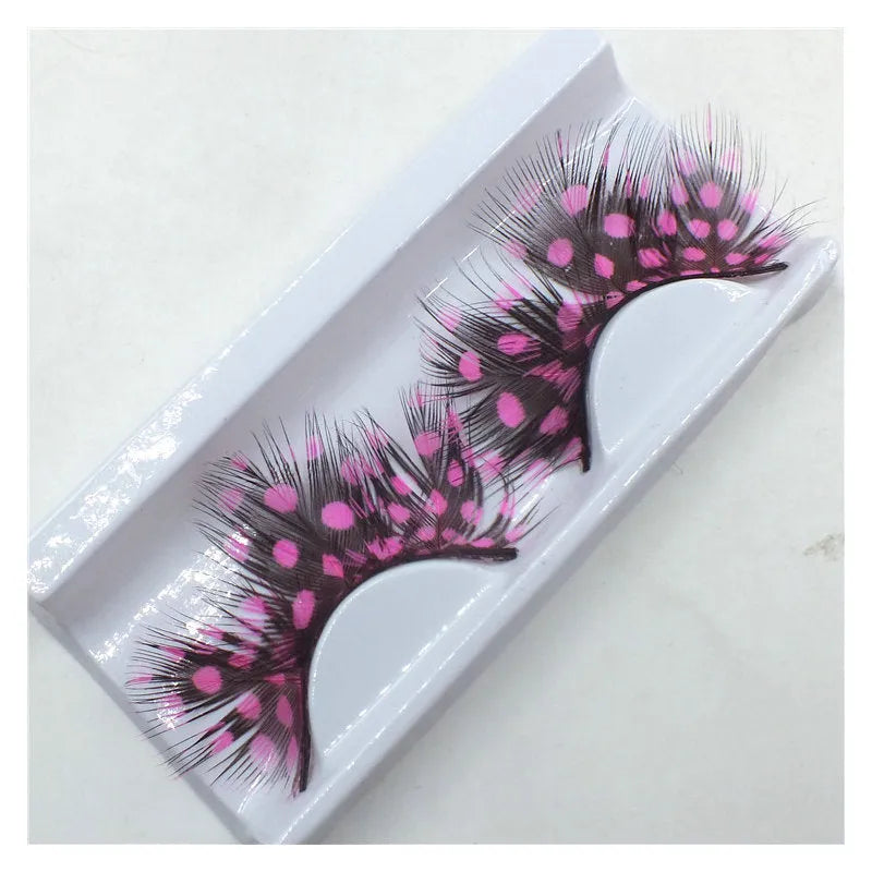 Handmade two-tone feather false eyelashes on a flat surface showing colour matching and feather texture