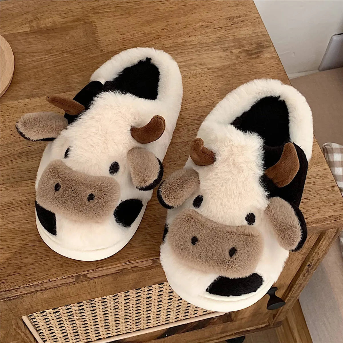 White and coffee cartoon cow slippers for women with plush faux fur and a textured non-slip sole.