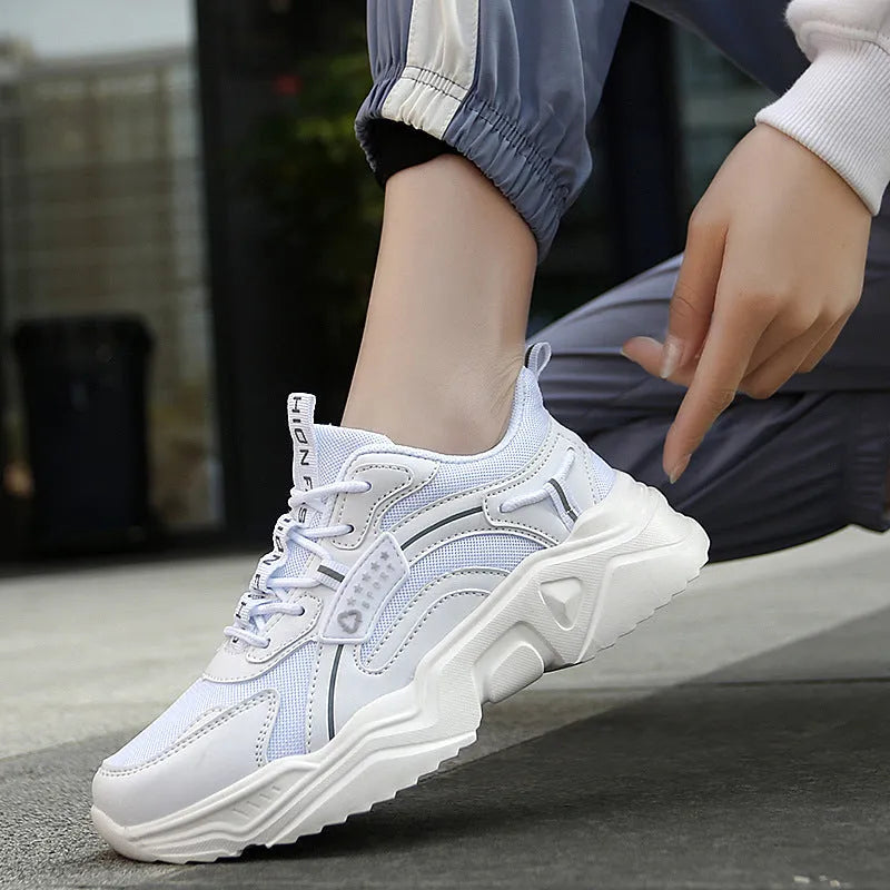 White women's casual mesh sports shoes with a thick sole, buckle detail, and round toe on a plain background.