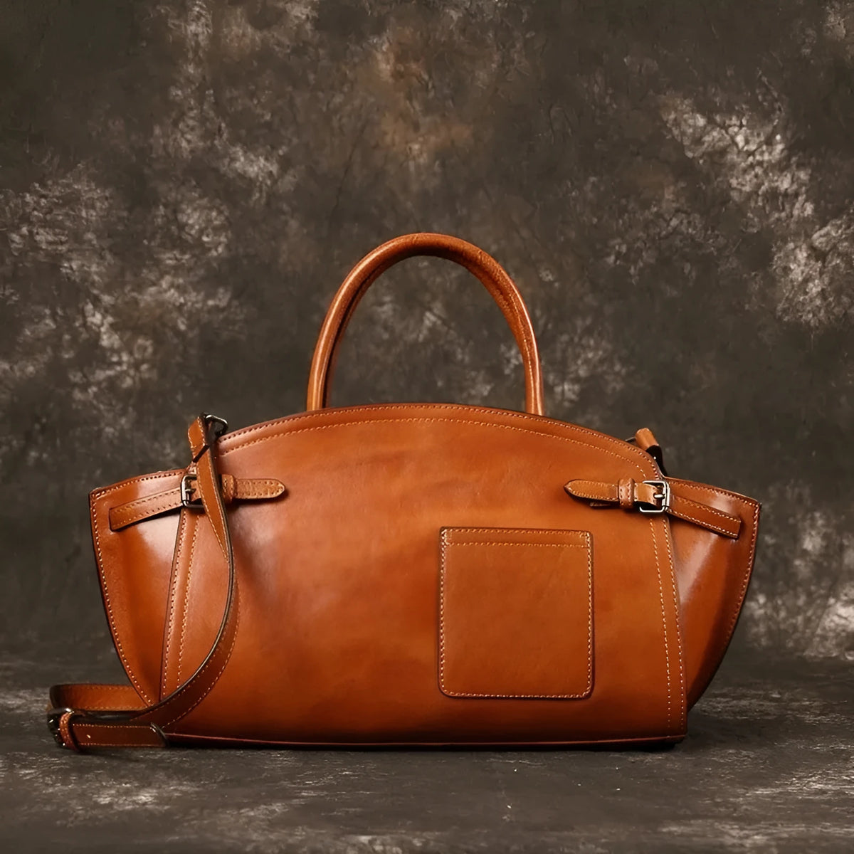 Genuine top grain leather women's crossbody bag in brown with dumpling shape and zip closure.