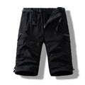 Man wearing thin cotton cropped overalls in army green, showing the relaxed summer fit.
