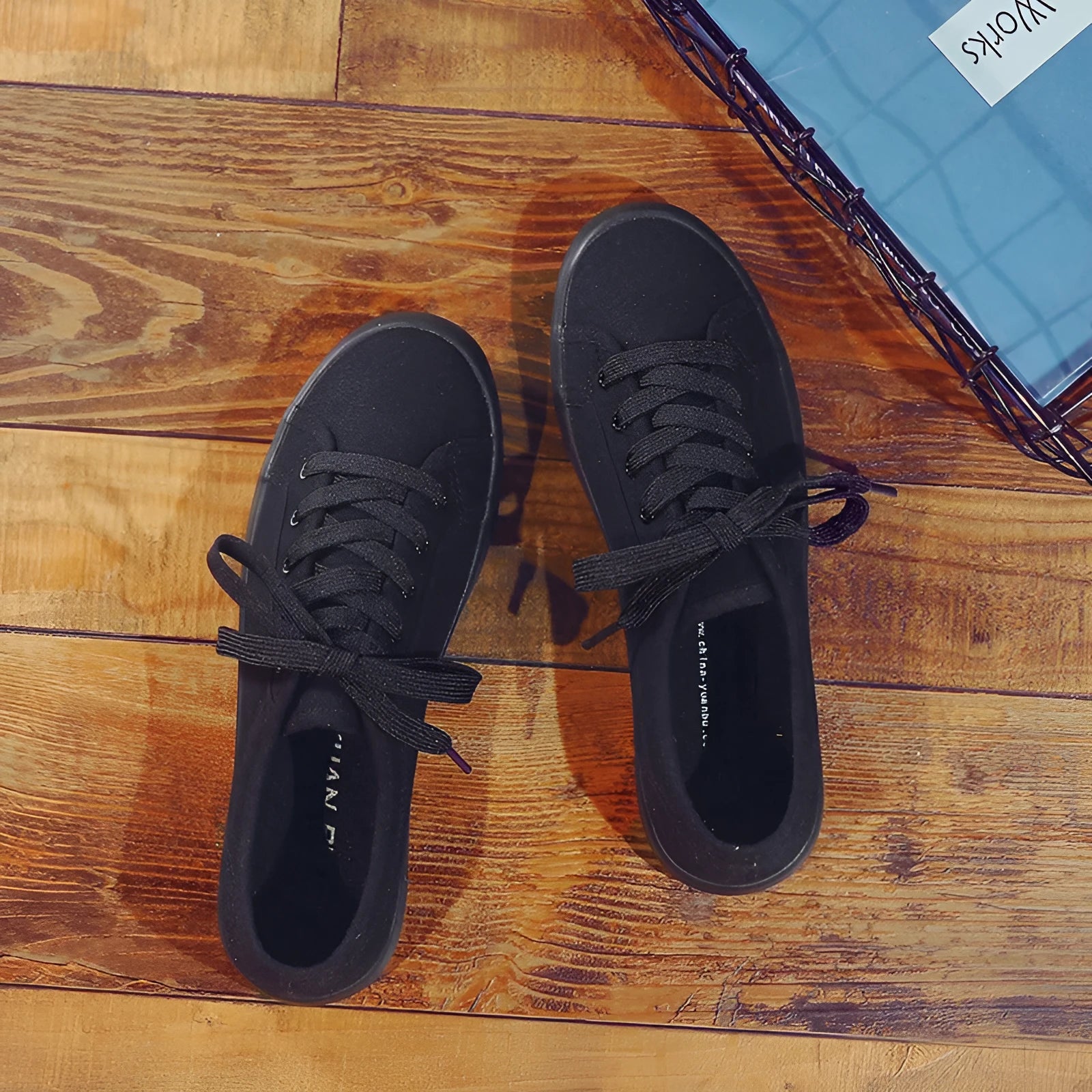 All-black women's canvas flat shoes with lace-up front and rubber soles.