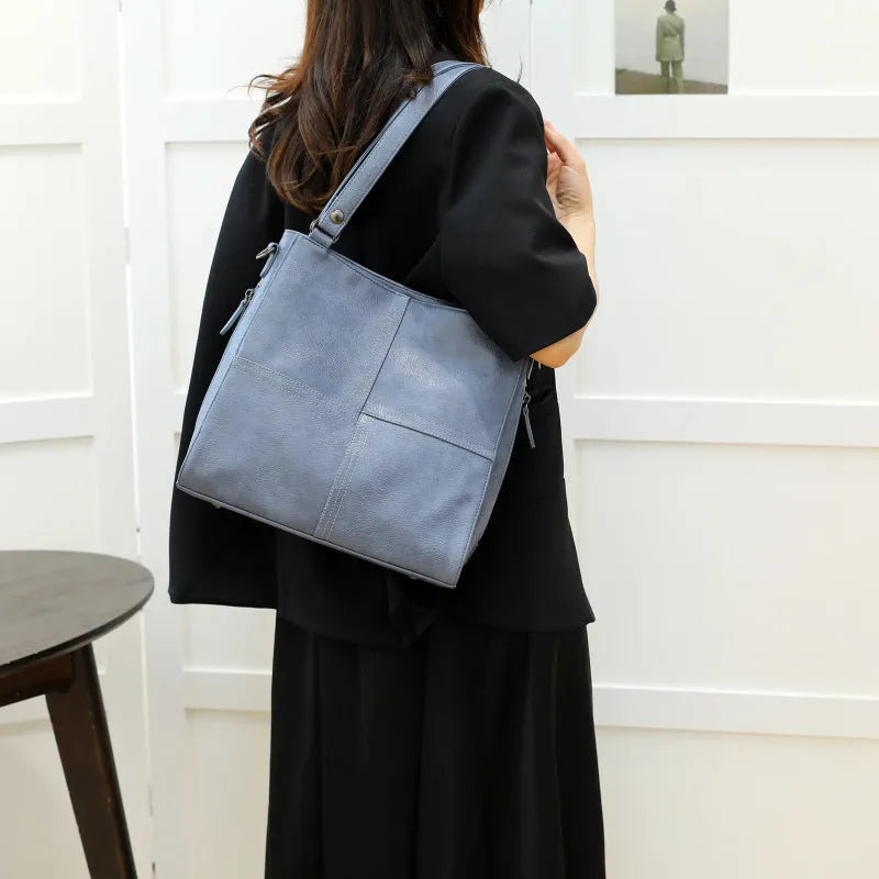 Soft PU retro style crossbody handbag in barrel shape showing pocket sandwich design.