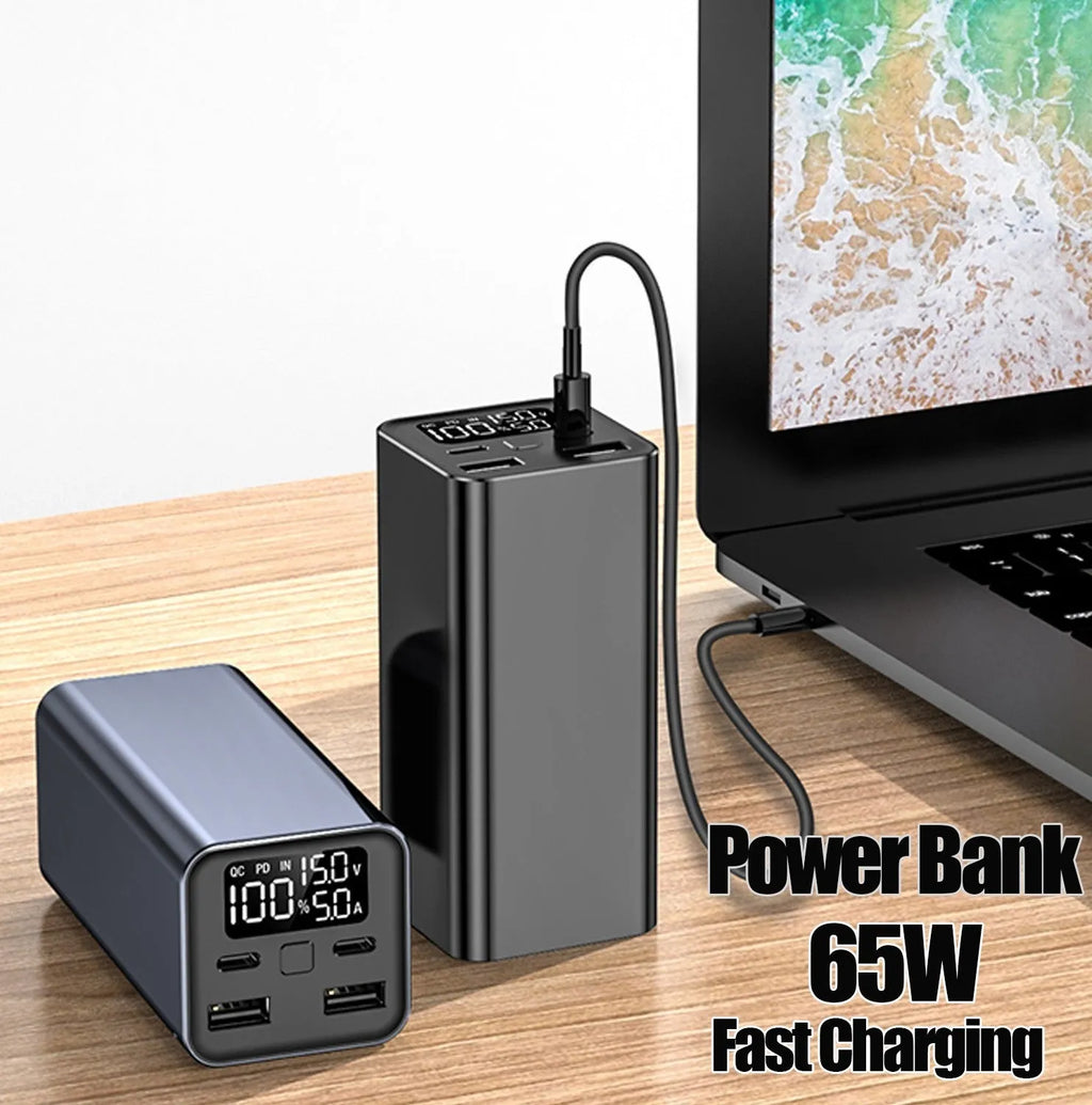 65W metal laptop power bank in black, blue, or grey colours showing size next to a laptop.