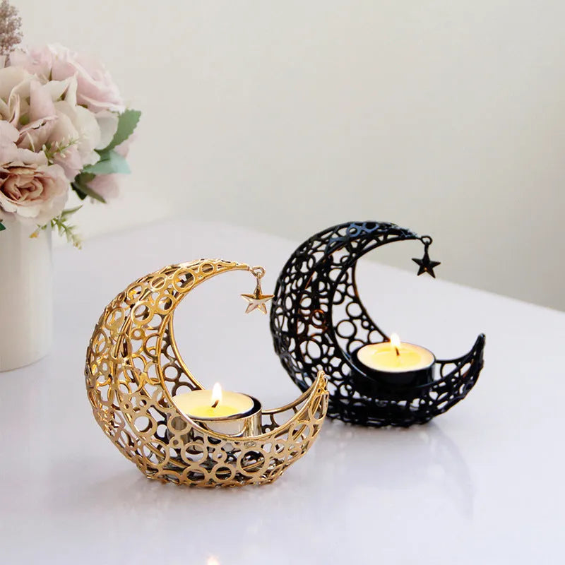 Black metal crescent moon candle holder with star cutouts on a table