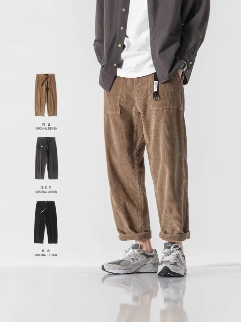 Man wearing loose straight leg tapered trousers in dark grey, showing relaxed fit and straight leg opening.