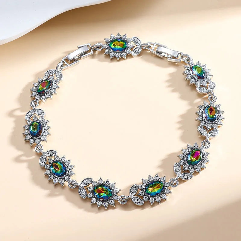 Simple electroplated alloy bracelet for women with inlaid zircon stone in one of nine colour options including ruby, emerald, and black onyx.