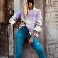 Lilac plaid print loose sweater with ribbed cuffs and hem on a hanger.