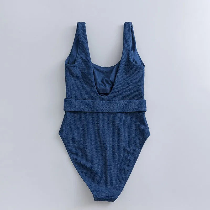 Navy blue one-piece women's swimsuit with a triangle neckline and slimming fit on a mannequin.
