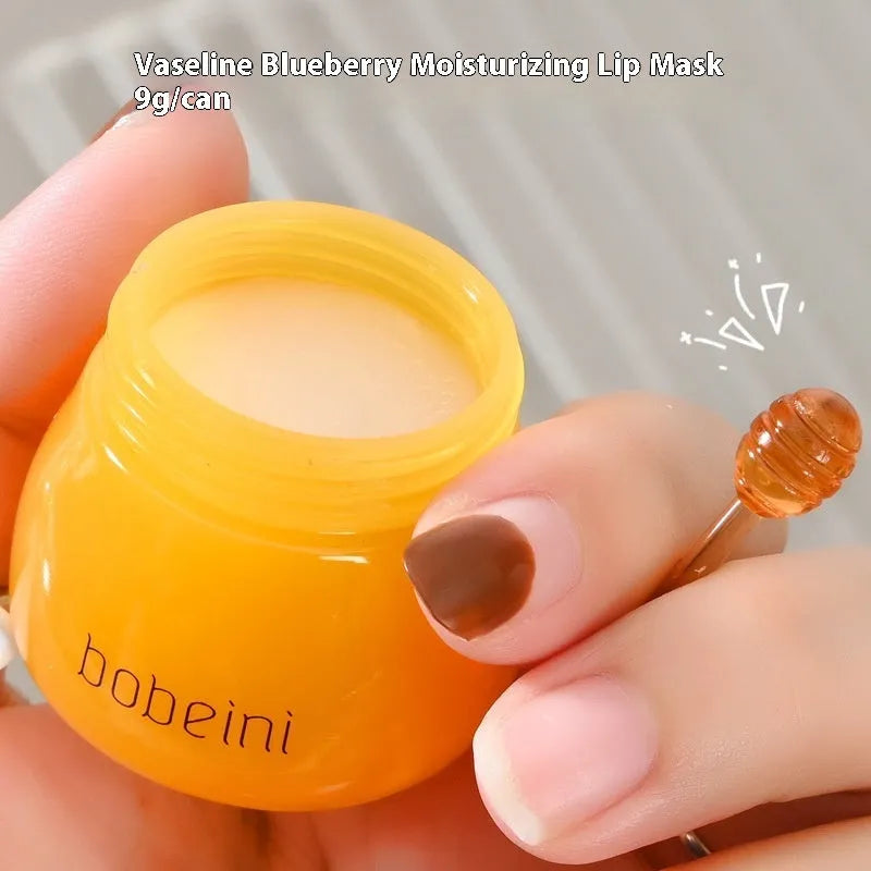 Honey pot style lip balm in 9g size with small application brush, shown in blueberry or pomegranate flavour.
