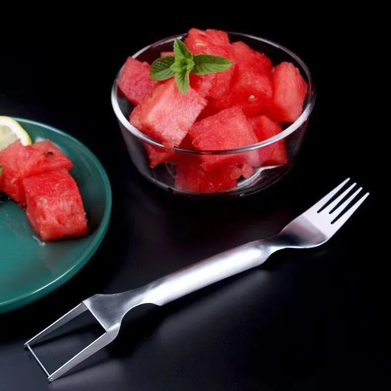 Silver stainless steel watermelon slicer with a 26cm handle and a 3.6cm wide rounded fork head.