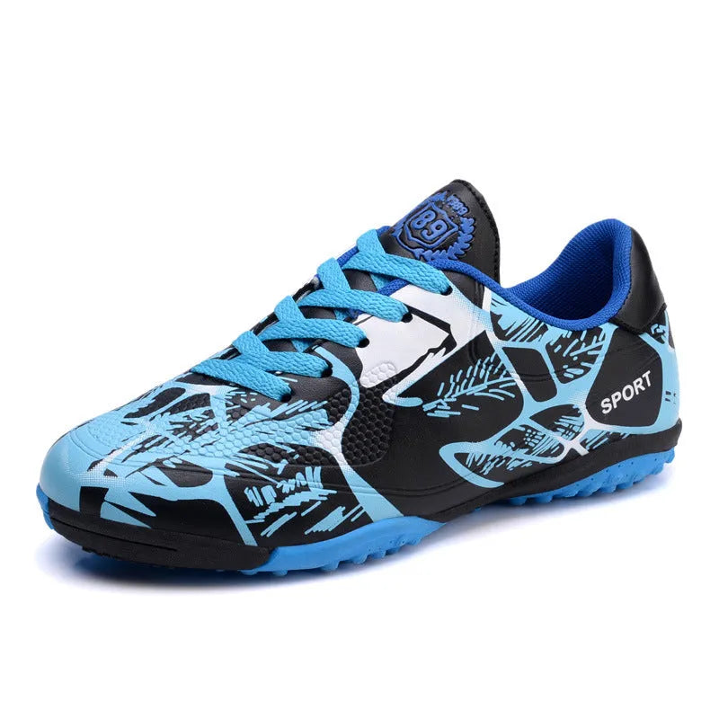 Red low-top soccer shoes with synthetic leather upper and spike outsole on natural grass
