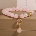 Pink crystal women's bracelet with a four-leaf clover pendant and sparkling rhinestone details.
