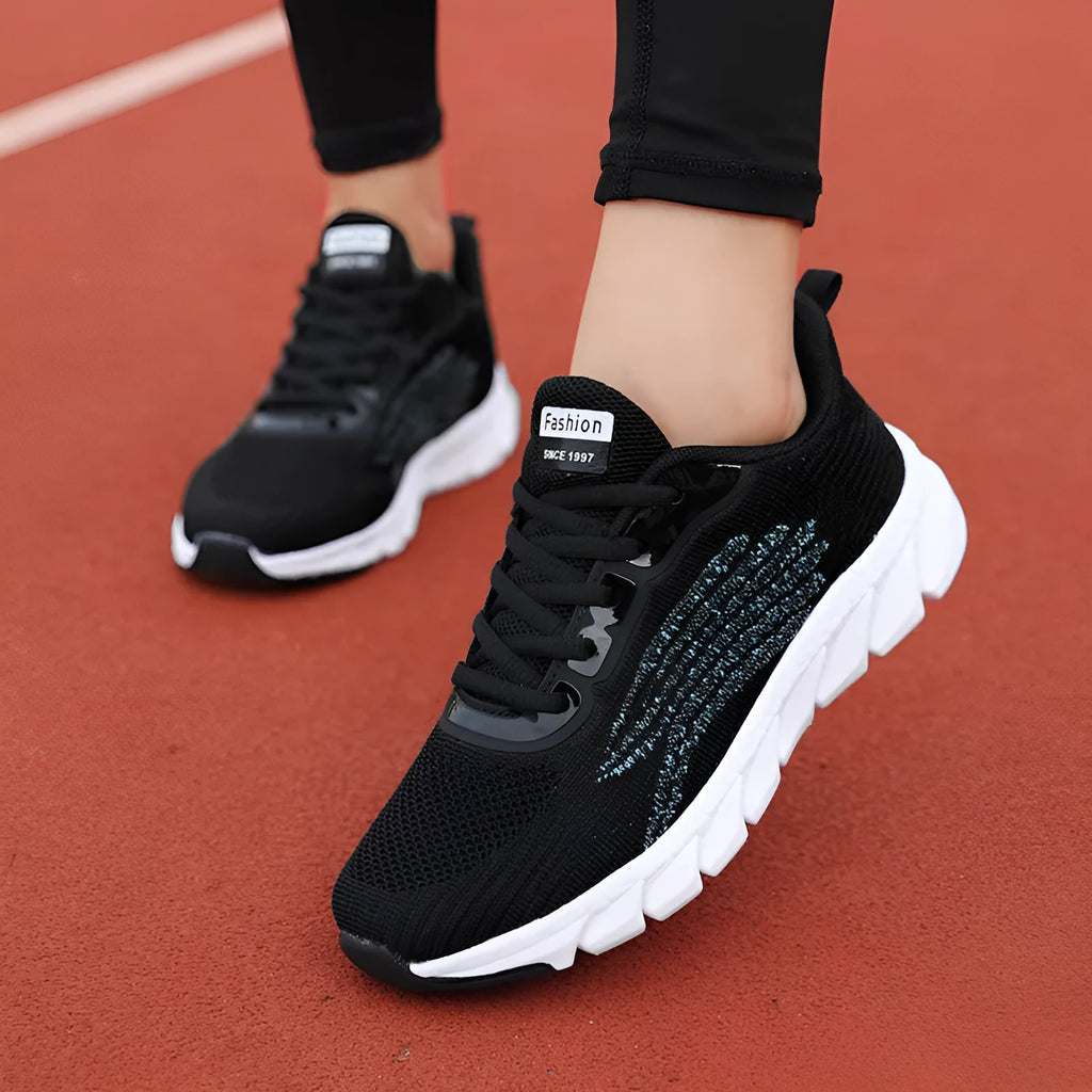 Low-top black and white running sneakers with cross strap design and MD sole