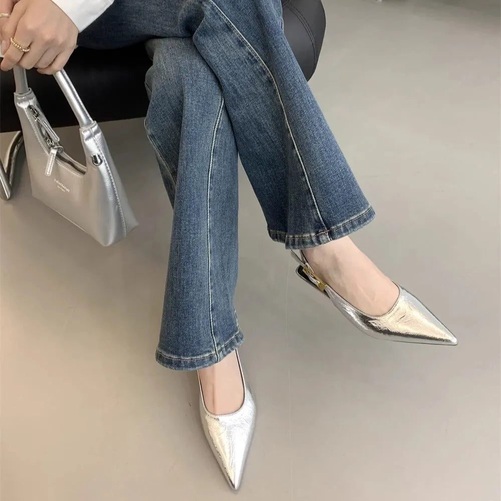 Black pointed toe low heel women's shoes with an ankle strap and rubber sole.