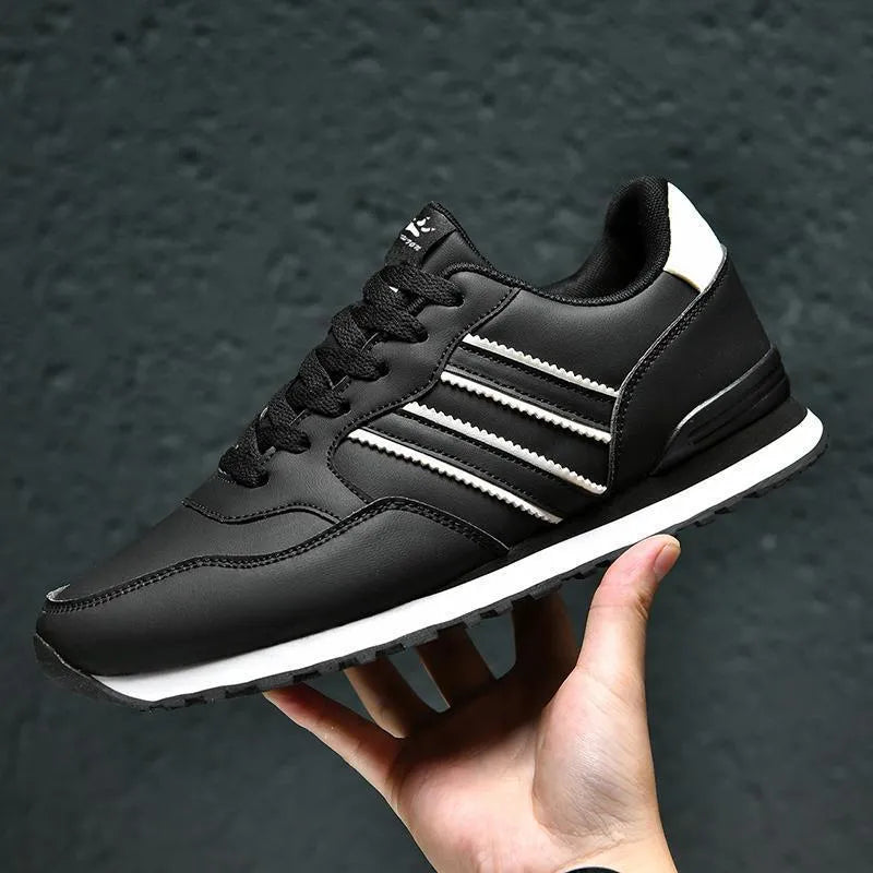 Men's black leather casual sports shoes with mesh lining and carved wing pattern design
